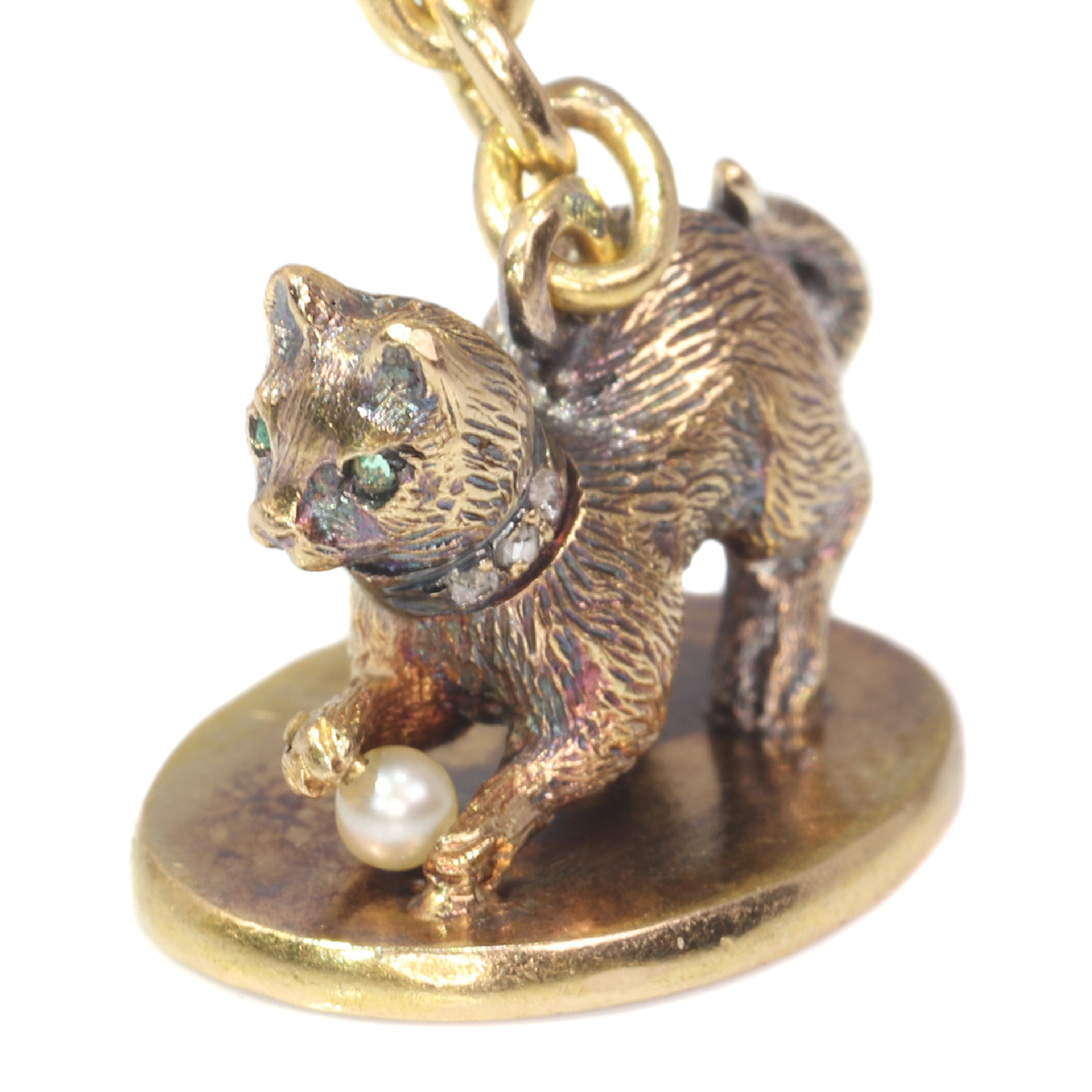 Antique gold kitten with diamond collar playing with little pearl on seal